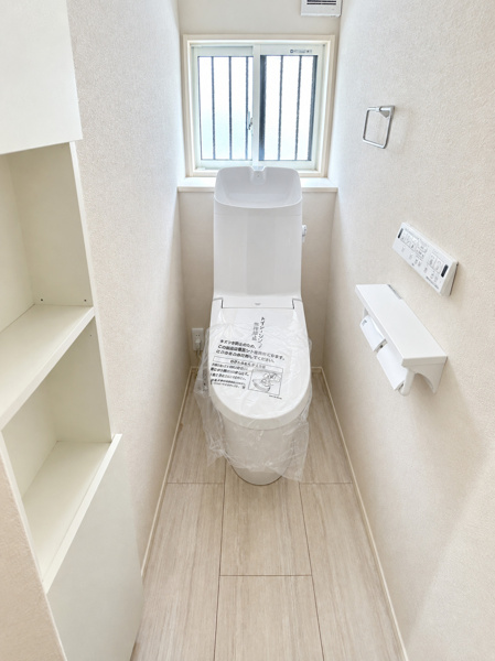 小窓から明るい光が入る清潔感たっぷりのトイレです！備え付けの収納棚があるため、予備のトイレットペーパーやお掃除用品もスッキリしまえます♪ペーパーホルダーが2つ並んでいるのも日常で便利なポイントです！