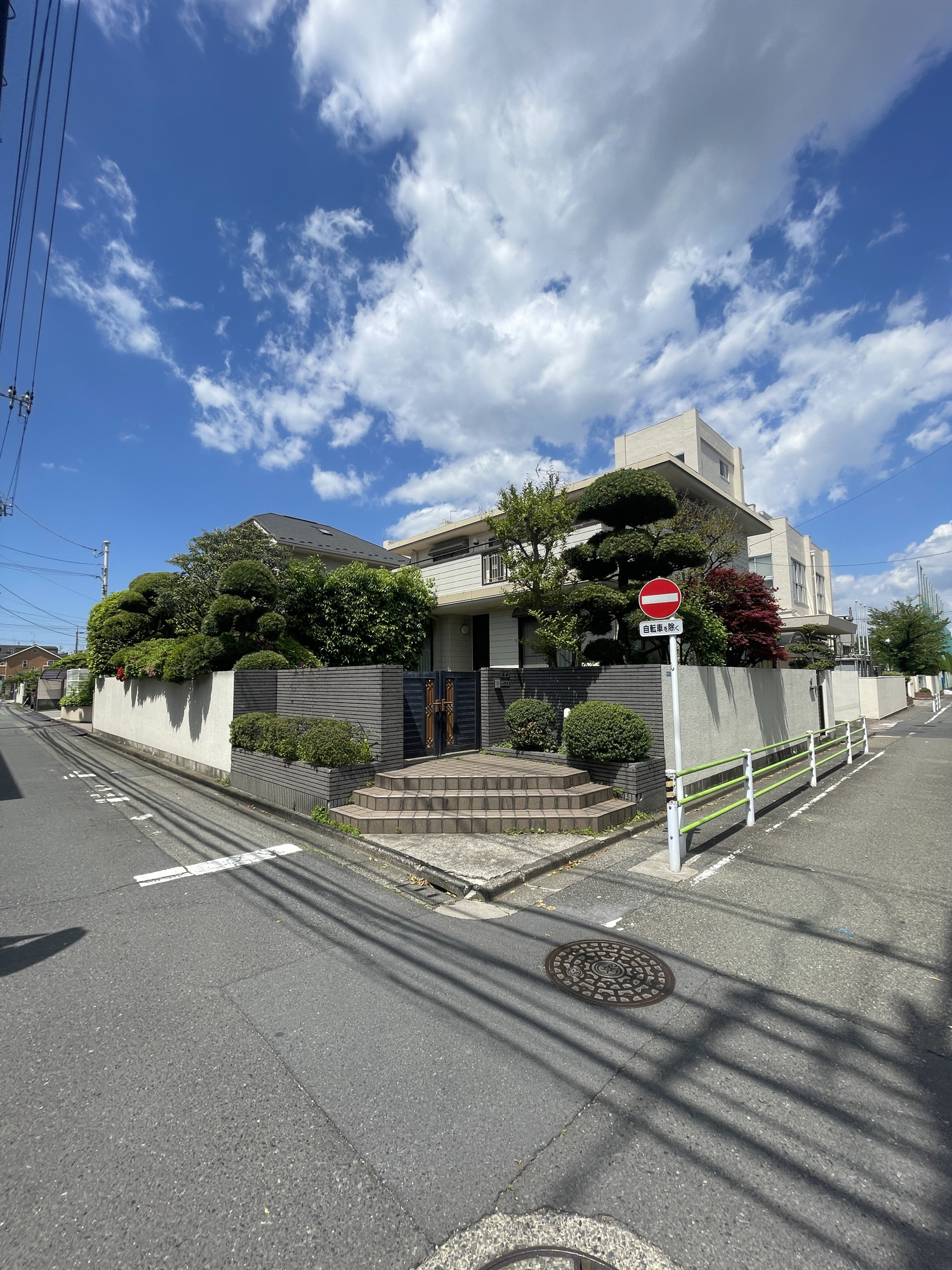 田園調布の前面道路含む現地写真|クラシカルな高級住宅街・田園調布の優雅な7LDK。1階にダイニングキッチン・バスルーム、2階にミニキッチン・シャワールームが設置されており、多様な生活様式に沿った邸宅です。東南角地で開陽当たり良好。