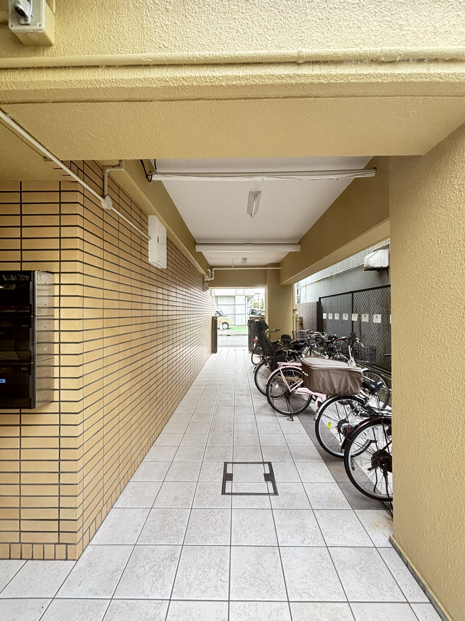 甲南第10兵庫コーポラス|すっきりと整えられた綺麗なタイル貼りの通路が奥へと続く、開放感のあるエントランスまわりです。