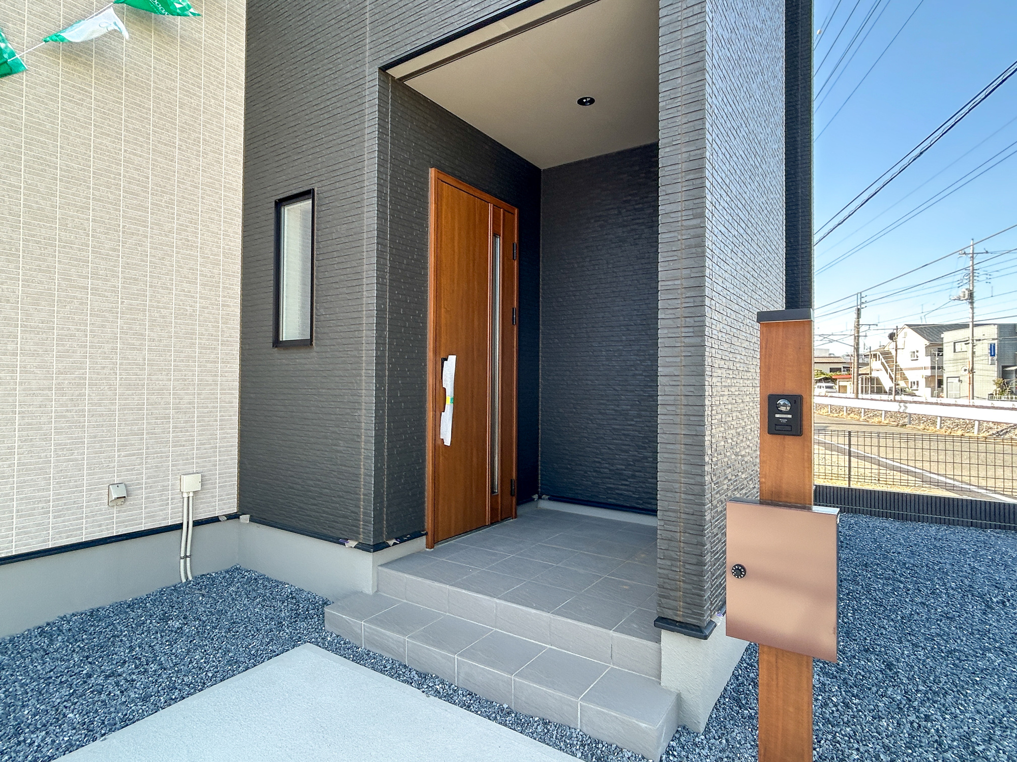 前橋市大友町第5期　新築住宅全1棟の玄関|上質感漂う玄関へのアプローチ。居住者の帰り、訪れる方を優しく迎える・安らぎに満ちた生活空間を予感させる。健やかな暮らしを楽しめそう
