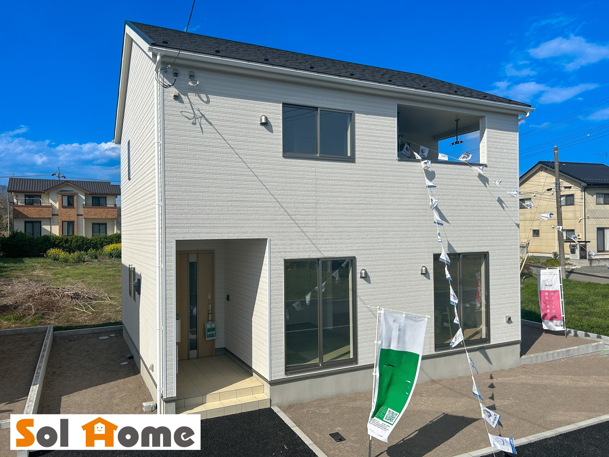 矢板市本町の新築一戸建の外観：施工例|【同社施工例】外壁が周囲の街並みと青空に生えるお洒落な仕上がり！周囲には高い建物のないエリア。青い空が大きく感じますね。