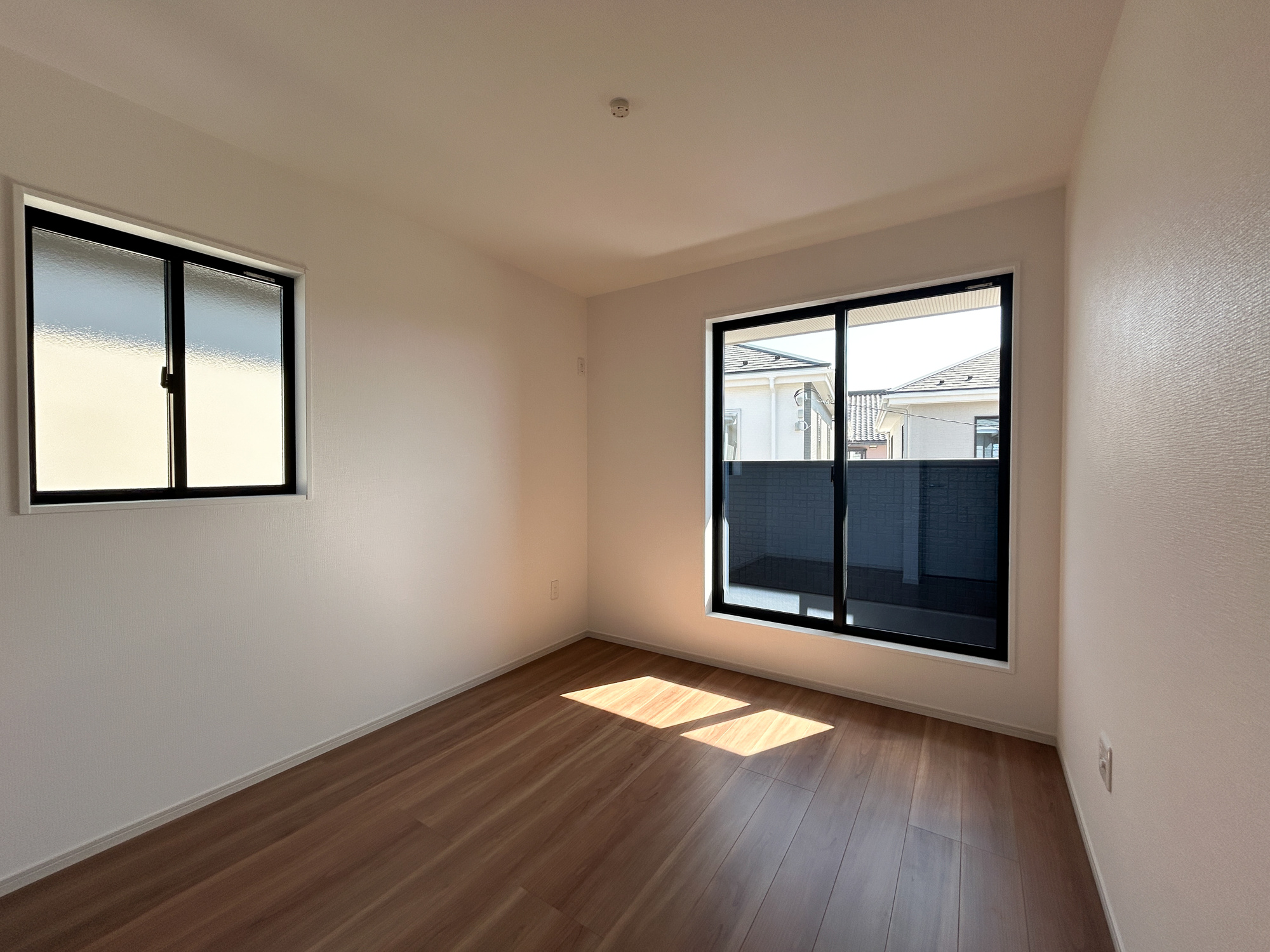 前橋市北代田町1期　新築住宅全3棟の洋室|木目のフローリングが暖かみのある室内に。明るい寝室で心地のいい朝を迎えられそう。