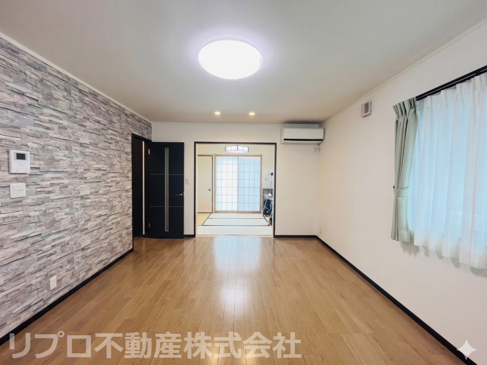 柏市小青田4丁目戸建の居間・リビング|石目調クロスが映える、和室続きの開放的な広々リビング♪全室電動シャッター＆窓が多く、採光・防犯面も安心！※CG加工により家具などは消しています