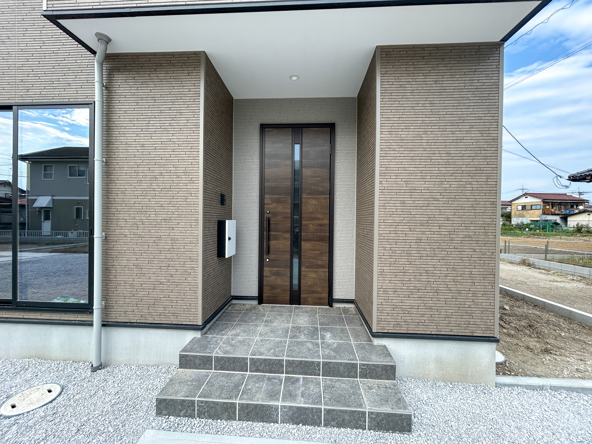 前橋市下新田町1期　新築住宅全3棟の玄関|明るく優しいイメージの玄関アプローチ。玄関上は屋根があるので雨の心配いらず♪