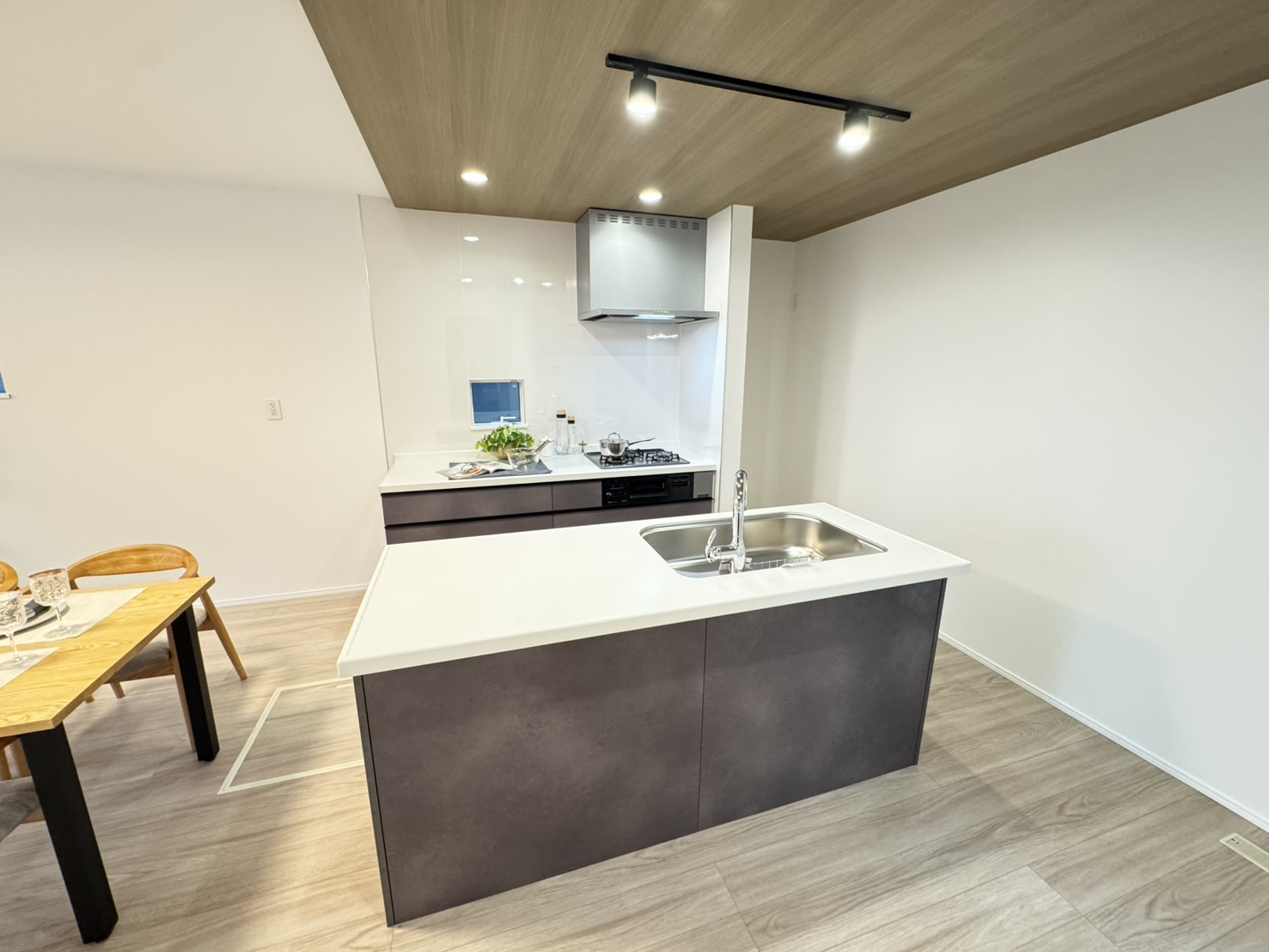 高尾通１丁目新築戸建のキッチン|家族を見守れる見晴らしのいいキッチン。キッチンにいてもお互いの姿が見えるから、家事をしながら見守り、会話ができます。子供たちも安心して宿題や遊びに集中できます。