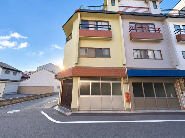 大阪市生野区小路東4丁目の外観|1階に事務所スペースを備えた3階建て住宅。道路に面した大きな開口部が特徴で、事務所や店舗など、事業内