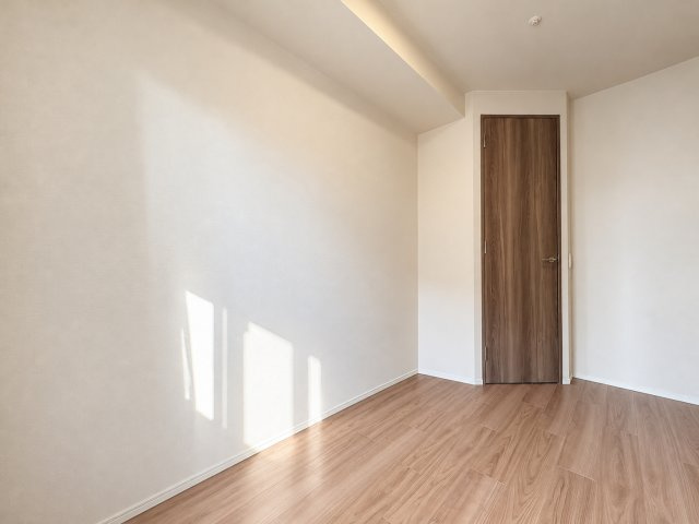 ワコーレ阿倍野播摩町ラフィリスの洋室|シンプルな内装と落ち着いた木目調の建具が印象的な洋室です。まとまった壁面があるため、デスクや収納家具