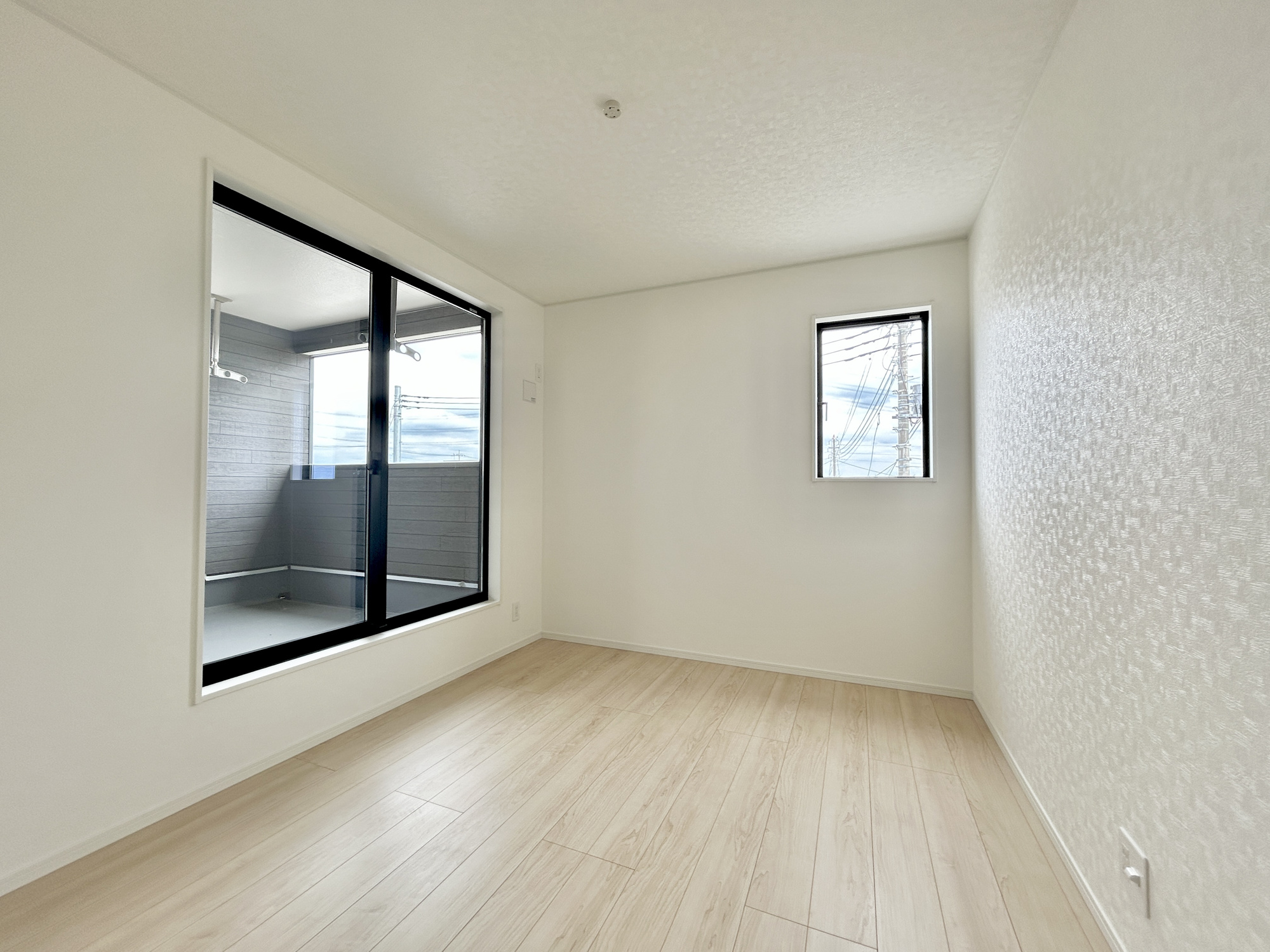 伊勢崎市境米岡第3　新築住宅全3棟の洋室|木目のフローリングが暖かみのある室内に。明るい寝室で心地のいい朝を迎えられそう。