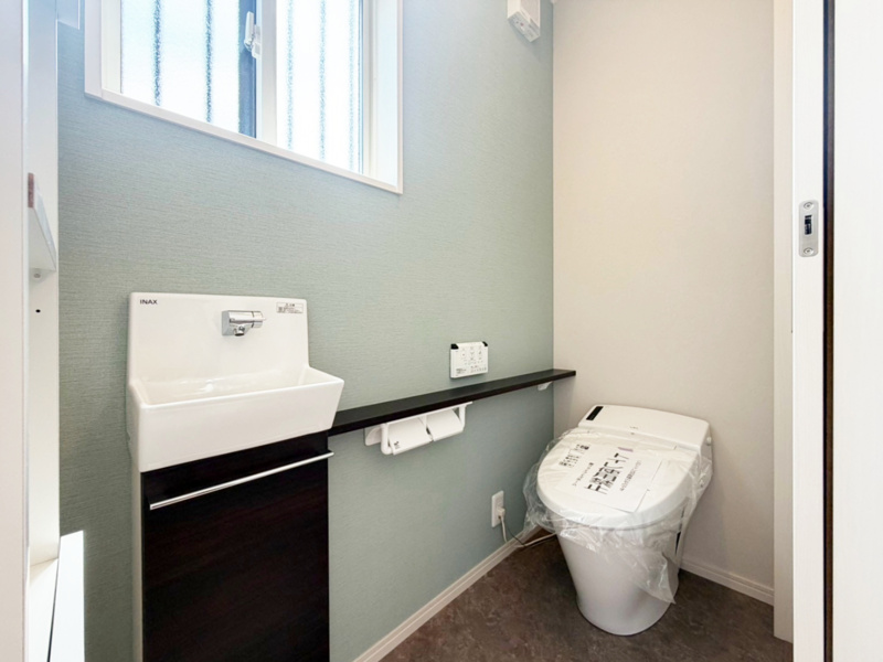 【５号棟　１Fトイレ】コンパクトながらトイレットペーパーや掃除用品もしっかり収納できるキャビネット付き！床に置く必要がないので衛生的です♪