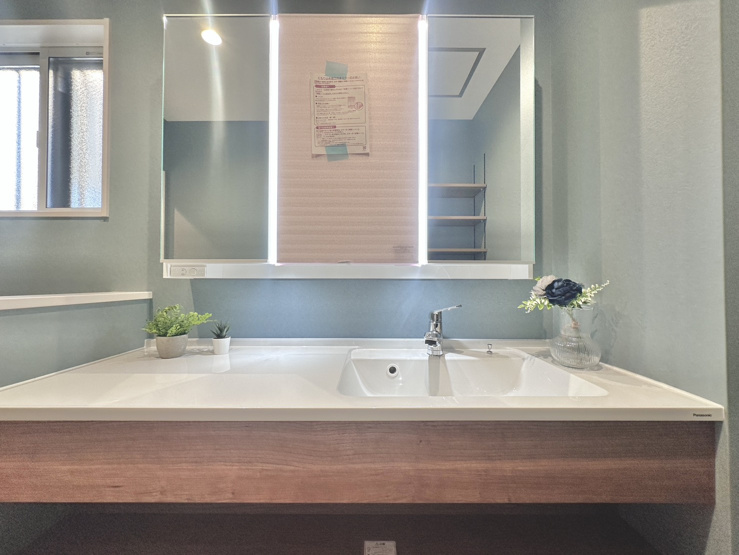 身支度がスムーズに整うワイドな洗面化粧台！洗面ボウル横に広々とした作業スペースを備え、共働きの忙しい朝の身支度も重ならず快適です♪明るい照明と清潔感ある空間で毎日のスタートを気持ちよく迎えられます！