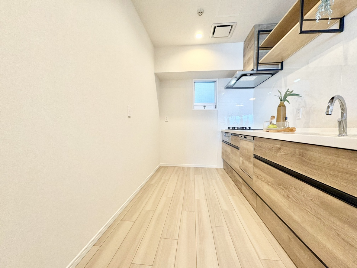 RICイーストコート3番街のキッチン|ご夫婦や親子で並んで立っても窮屈さを感じない、ゆとりある通路幅を確保。背面に大型冷蔵庫やカップボード（食器棚）を機能的に配置しやすく、食材の取り出しから調理、片付けまでの生活動線もスムーズです。