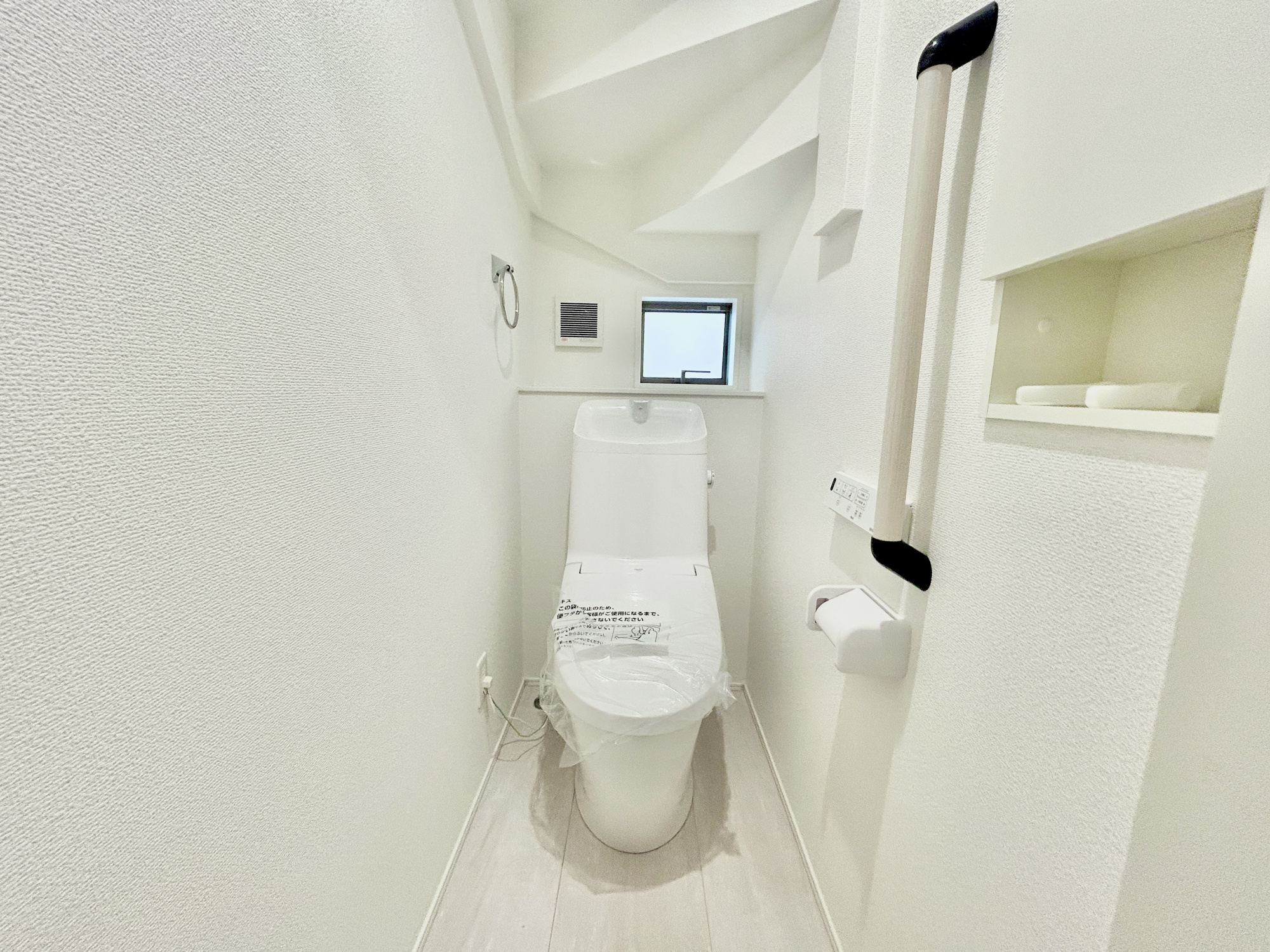 玉村町下新田3期　新築住宅全2棟のトイレ|節水性能の高いトイレはもちろんウォシュレット付き♪便器のフチがないタイプなので、お掃除もサッとひと拭きでOK！壁埋込型収納も付いており、スッキリ広々とご利用いただけます。