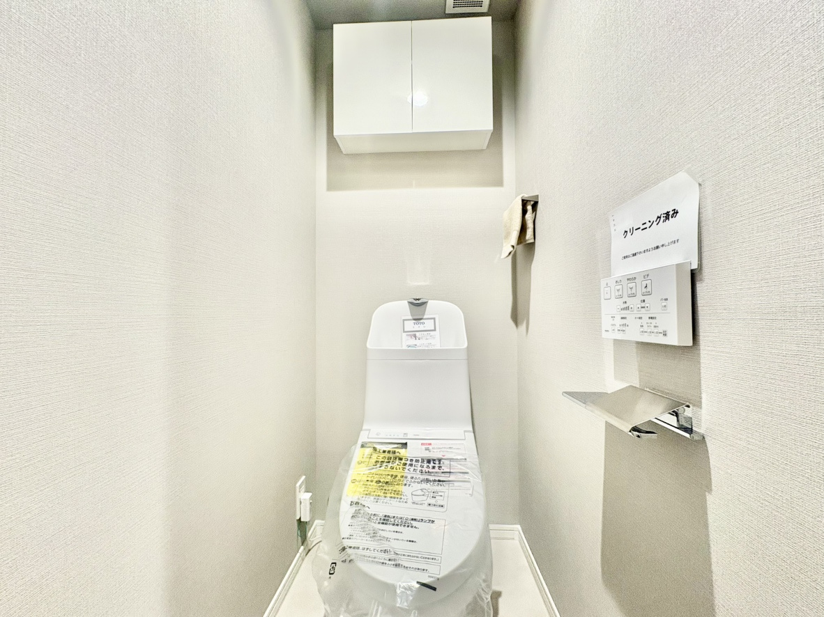 メゾン岡本南のトイレ|トイレ上部にはトイレットペーパーや掃除用品をすっきり目隠し収納できる扉付きの吊戸棚を設置。余計なものを床に置かずに済むため、空間を広く使えてお掃除も簡単、常に清潔な状態をキープできます。